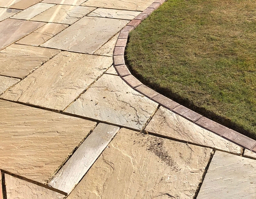 Curved patio surrounding grass area.