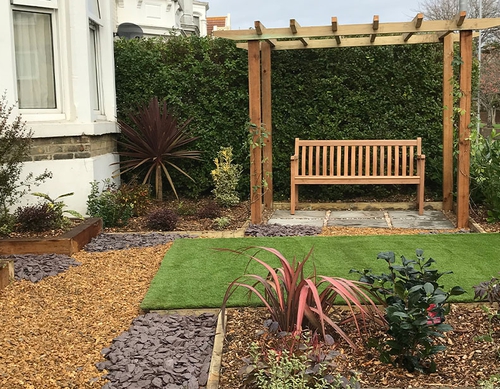 Landscaped front garden with artificial turfed area.