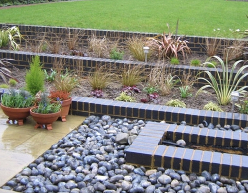 Landscaped raised flower beds with blockwork edge.